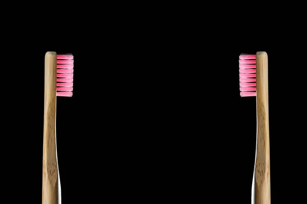 環境に優しい製品コンセプト 黒の背景にピンクの毛が分離された2本の竹の歯ブラシを無駄にします 生分解性材料 天然有機木のブラシ 地球を守れ スペースのコピー — ストック写真