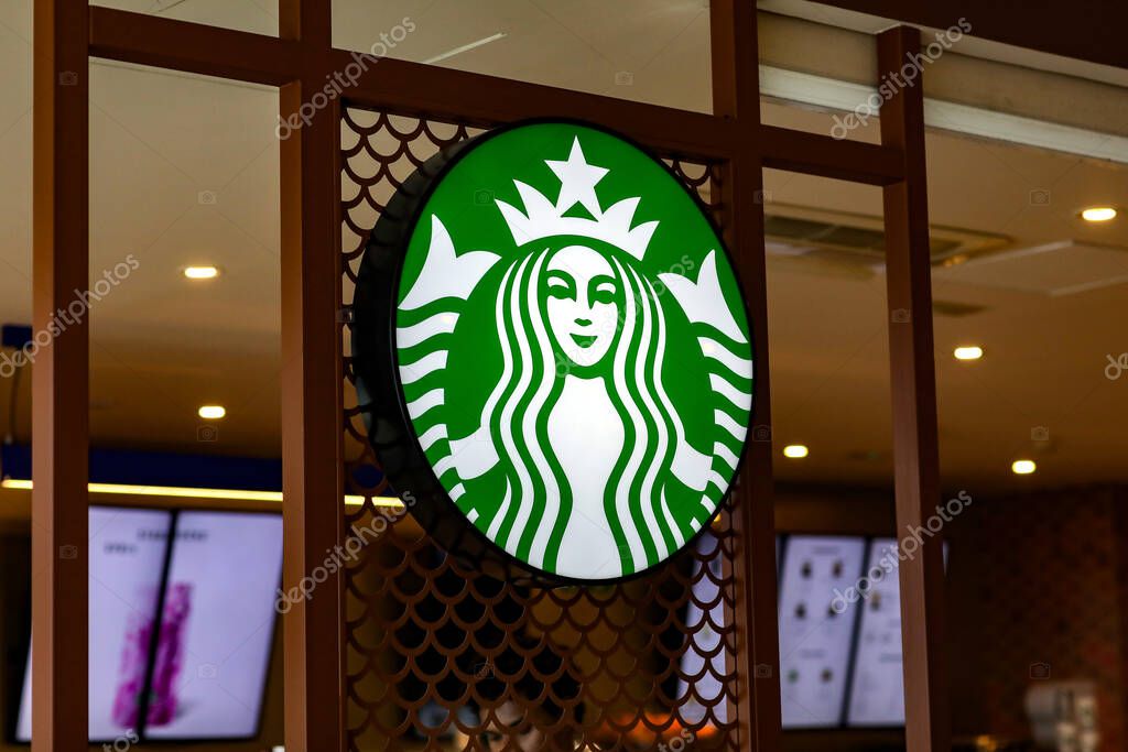 Valencia, Spain: March 18, 2023: Trademark green logo Starbucks with two-tailed mermaid siren inside coffeeshop. Starbucks Corporation is multinational chain of coffeehouses and roastery reserves.