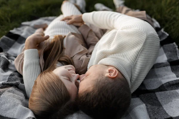 祝你全家快乐男人和怀孕的妻子在户外草地上拥抱 躺着和亲吻 母亲节 父亲节 为人父母 为人母 爱的概念 — 图库照片