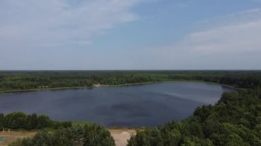 Yazın nehir ve ormanın havadan görünüşü, bulutlu gökyüzü. Kum gölü kıyıları ve yeşil ormanlık üzerinde uçuyor. Doğal manzaralı bir yer. Ekosistem ve sağlıklı çevre geçmişi.