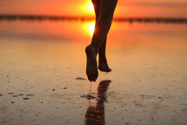アクティブな夏の旅行の休日 エネルギーの小さな子供の女の子の足のシルエットのトリミングされた写真は 男の子が楽しいランを持っていて 日没時にビーチで遊んでいます ライフスタイルと幸福の概念 子供の日 — ストック写真