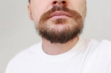 Sakallı adamın kesilmiş fotoğrafı ilk kez kabarık sakal ve bıyıktaki gri tüyler. Erken yaşta melanin kaybı, genetik yatkınlık, hormonal bozukluk, endokrin sistemi bozuklukları..