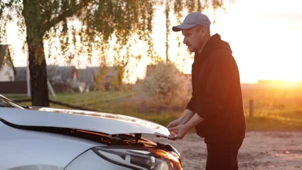 Fiatalember Kinyitja Egy Autó Motorháztetőjét Szabadban Esténként Naplementekor Járművezető Autó — Stock videók