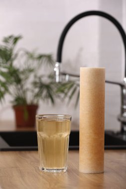 Paslı kartuş ve mutfaktaki masanın üstünde kirli su bardağı kullanılmış. Ev suyu filtreleme sistemi içilebilir durumda. Musluk suyunun demir maddeyle kirlendiğine dair kanıt