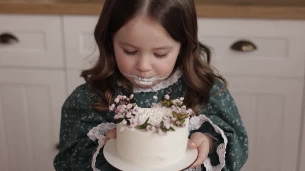 Urocza Dziewczynka Nosi Świąteczną Sukienkę Bierze Gryza Ozdobionych Kwiatów Tort — Wideo stockowe