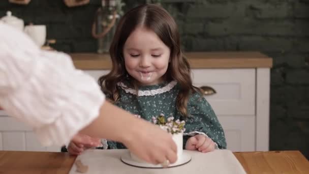 Mom Helps Her Adorable Child Girl Take Bite Out Decorated — Stock Video