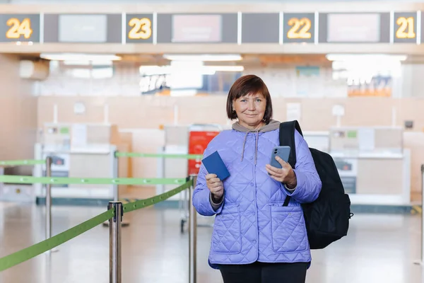 Podróżująca Średnim Wieku Kobieta Plecakiem Posiada Paszport Korzysta Telefonu Komórkowego — Zdjęcie stockowe