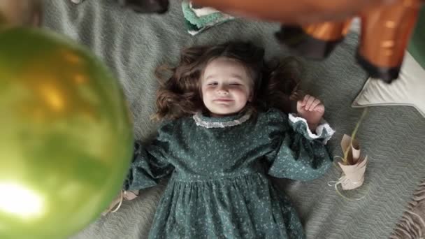 어린이 소녀가 러시아 스타일의 드레스를 침대에 웃으며 카메라를 파티를 풍선으로 — 비디오