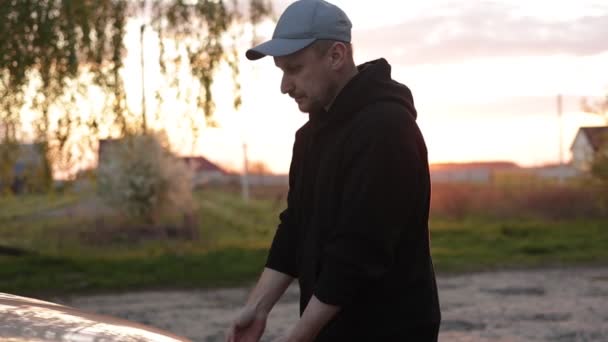 Ung Mand Åbner Kølerhjelmen Bil Udendørs Aftenen Solnedgang Chauffør Kontrol – Stock-video