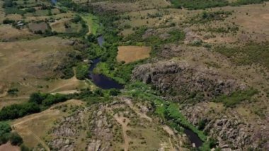 Ukrayna 'nın Mykolaiv bölgesindeki Mertvovod Nehri' nin Aktovsky Kanyonu kuş bakışı görüntüsü. Güneşli yaz günlerinde kanyonun dibindeki yemyeşil ve kayalıklarda sığ nehir akar..