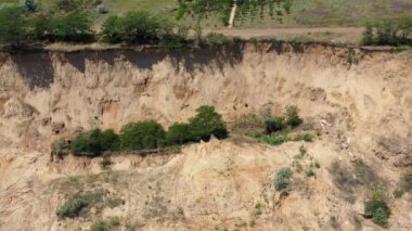 Deniz kıyısında heyelan bölgesi olan bir yer. Harabe sahil, kil kayalıkları, tehlike noktası, deprem. Kamera aşağı iniyor. Ukrayna, Odessa yakınlarındaki Karadeniz kıyı şeridinin insansız hava aracı görüntüsü
