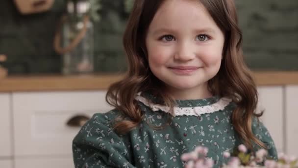 明るい小さな女の子の肖像4 5年は花のドレスでお祝いのスタイリッシュなレトロな緑を身に着けている彼女の誕生日を祝い スタイリッシュな家庭のキッチンでケーキを食べる準備ができています 子供の日 — ストック動画
