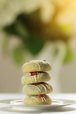 Bir yığın ev yapımı zencefilli kurabiye kibritle süslenmiş süblimleşmiş çilek ve arka planda yeşil vanilyalı krema. Şeker, glüten ve laktozsuz vejetaryen