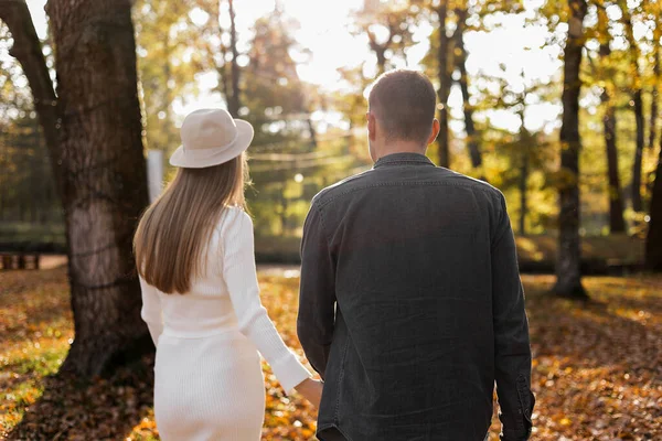 Para Mężczyzna Ciężarna Żona Trzymają Się Ręce Spacerują Jesiennym Parku — Zdjęcie stockowe