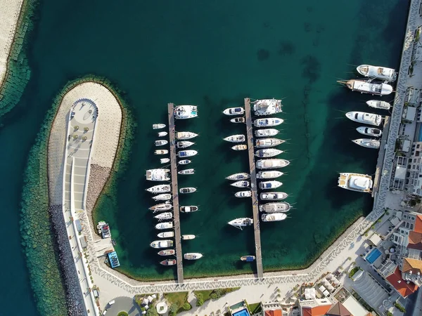 stock image Aerial view of luxury sailing yachts and boats in yacht club near wooden piers. Top view of european city. Large boat parking near sea coast. Road to the lighthouse. Yachting in summer concept