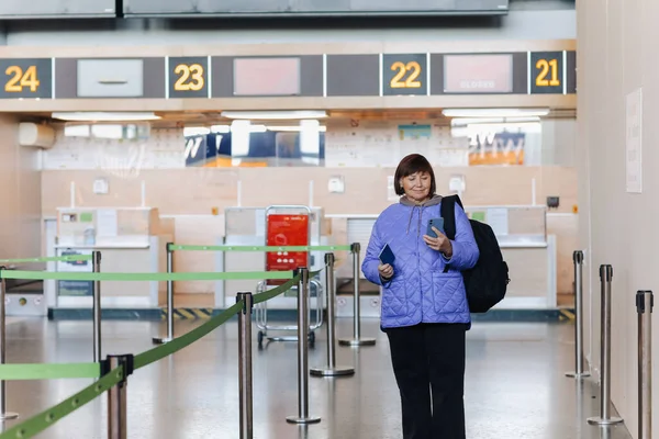 가방을 여행하는 여성은 서비스 책상을 터미널에서 전화를 활동적 퇴직자들 관광에 — 스톡 사진