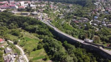 Ukrayna 'daki Kamenets-Podolsky şehrinin insansız hava aracı görüntüsü. Kamianet-Podilskyi şehri, beton köprüyle yeşil kanyondan kaleye. Avrupa 'nın tarihi eski şehrinin üzerinde uçuyor..