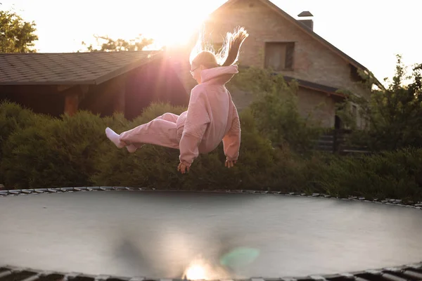 stock image Happy little child girl having fun and jumps on trampoline outdoors, at backyard of the house on sunny summer day, active recreation on summertime vacation. Happy childhood concept. Children's day