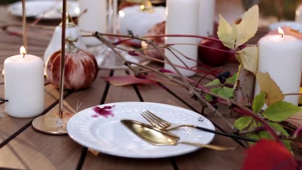 Table Setting White Plates Gold Cutlery Maple Leaves Pumpkins Burning — Stock Video