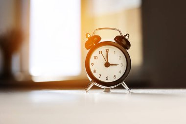 Beyaz ve gri arka planda izole edilmiş geçmişe dönük siyah ve beyaz çalar saat gölgesi öğleden sonra üç saat gösteriyor. Siesta zamanı, mola, öğle yemeği konsepti.