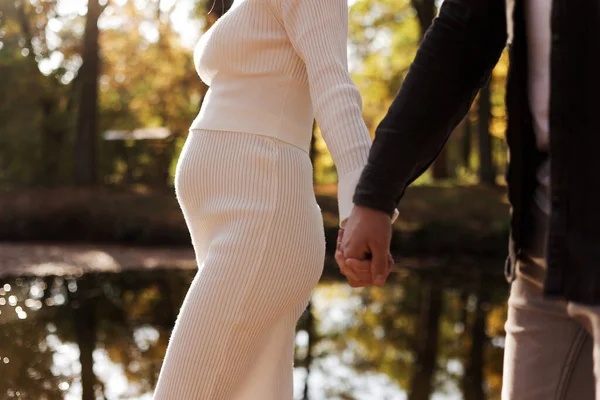 Para Mężczyzna Ciężarna Żona Trzymają Się Ręce Spacerują Jesiennym Parku — Zdjęcie stockowe