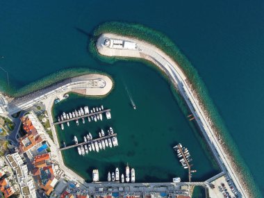 Ahşap rıhtımların yakınındaki yat kulübünde lüks yelkenli yatları ve tekneleri gösteren hava manzarası. Avrupa 'nın en iyi manzarası. Deniz kıyısına yakın büyük bir tekne parkı. Deniz fenerine giden yol. Yaz konseptinde yat.