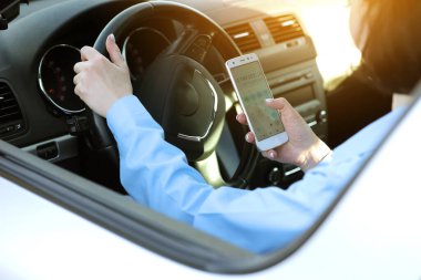 Tanınmayan iş kadını, arabanın yanından geçerken cep telefonu hesap makinesi uygulaması kullanıyor. Kadın girişimci çalışan maaşlarını, gelirlerini ve giderlerini hesaplar. Uzak iş konsepti.