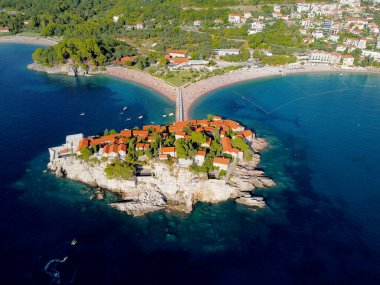 Karadağ 'ın güzel bir yaz gününde Sveti Stefan adası ve kıyılarının havadan görünüşü, insansız hava aracı uçurmaktan. Aziz Stephen 'ın lüks tatil köyünün üstündeki panoramik. Turizm ve eğlence kavramı. Fotoğraf:.