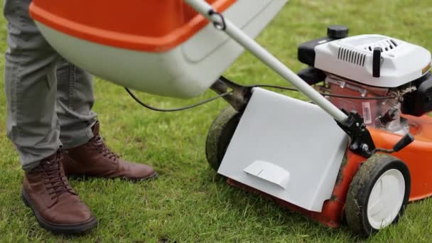 Gardener Man Casual Clothes Carries Plastic Lawn Mower Box Cut — Stock Video