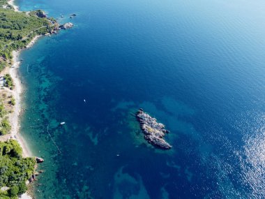 Küçük kayalık adanın yukarıdan görünen havadan görünüşü, etrafındaki mercan resifleri. Turist tekneleri, denizde yatlar. Seyahat yerleri. Güzel manzara. İHA uçuşu.