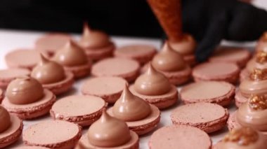 Şefin ellerinin çikolatalı badem kabuğuna fındıklı tuzlu karamelli ganache kreması koyması. Makarna Fırını Konsepti. Pişirme, Yemek ve Pişirme Konsepti. Şekerleme ve Pişirme Konsepti