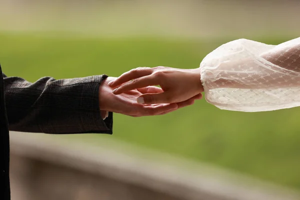 白いドレスの花嫁の手と グリーンの背景に指に触れるスーツで成長 人々のコンセプトを救い サポートする手助けをします 結婚式の日 バレンタインデー — ストック写真