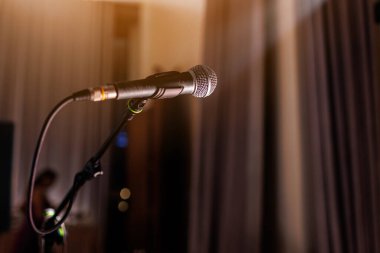 Mikrofon sahnede, projektör ışığıyla yaklaş. Konser salonunda ya da konferans odasında profesyonel mikrofon, karaoke, gece kulübü, bar. Halka açık etkinlikler, festival, düğün. Boşluğu kopyala