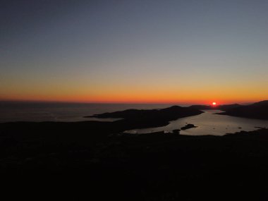 Kotor, Adriyatik, Karadağ 'daki Kotor Körfezi' nde güzel gün batımı veya gündoğumu manzaralı hava aracı manzarası. Parlak turuncu güneş ışığıyla sakin bir ufuk çizgisi. Yaz tatili kavramı.