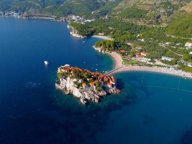 Karadağ 'ın güzel bir yaz gününde Sveti Stefan adası ve kıyılarının havadan görünüşü, insansız hava aracı uçurmaktan. Aziz Stephen 'ın lüks tatil köyünün üstündeki panoramik. Turizm ve eğlence kavramı. Fotoğraf:.