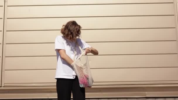 忧心忡忡的年轻女子在户外寻找棉花包中的污迹 时尚环保配件 千年女性持有可重复使用的绳子袋 没有塑料生活方式的替代概念 — 图库视频影像