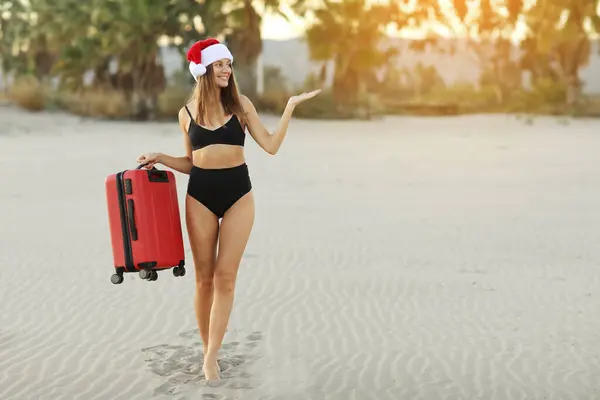 Mayo Giymiş Noel Baba Kadın Elinde Kırmızı Bavulla Plajda Tropik — Stok fotoğraf