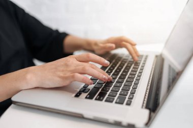 Ev ofisindeki dizüstü bilgisayarda yazı yazan kadının ellerini kapat. İnternet pazarlaması, serbest çalışma, evden çalışma, internet üzerinden eğitim, uzaklık eğitimi için bilgisayar kullanan iş kadını ya da öğrenci.