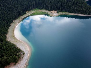 Crno Jezero veya Kara Göl, çam ormanı ve Karadağ 'ın Zabljak kentindeki Durmitor ulusal parkındaki uçurumların inanılmaz hava aracı görüntüsü. Seyahat, çevre, doğa güzelliği, rahatlatıcı. UNESCO Dünya Mirası.