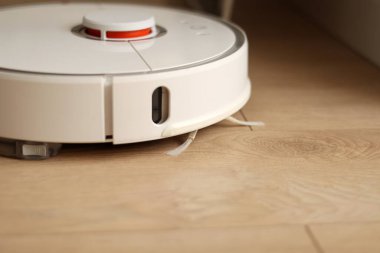 Kablosuz özerk akıllı robot elektrikli süpürge oturma odasındaki modern fayanslarla yerleri süpürüyor. Otomatik itişli temizlik robotu. Yer temizleme sistemi. Ev kumandası aygıtları