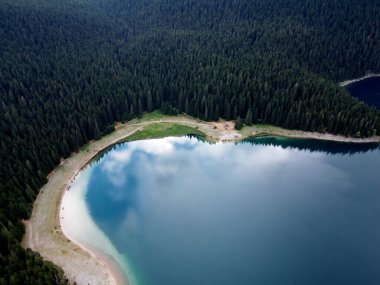 Crno Jezero veya Kara Göl, çam ormanı ve Karadağ 'ın Zabljak kentindeki Durmitor ulusal parkındaki uçurumların inanılmaz hava aracı görüntüsü. Seyahat, çevre, doğa güzelliği, rahatlatıcı. UNESCO Dünya Mirası.