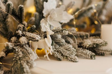 Şenlik arka planı. Yapay kardaki firavun dalları, Noel süsüyle süslenmiş altın çelenk ışıkları, parlak mücevherler, parlak çiçekler, geyikler, mumlar. Yeni yıl 2024 Tatil.