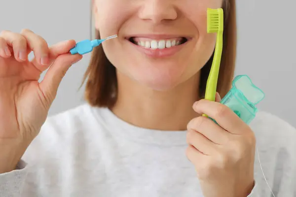 白い歯を持つ認識できない女性は 口腔疾患を予防するために歯のフロス 歯ブラシ 歯ブラシを保持しています ヘルスケア歯科および口腔衛生コンセプト 毎日の予防をルーチン ロイヤリティフリーのストック画像