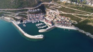 Lustica Körfezi, Adriyatik denizi, Karadağ 'ın havadan görünüşü. Binaların üst manzarası, liman limanı, demirli tekneler, yatlar ve deniz feneri, dağların arka planında. Yeni modern lüks tatil köyü.