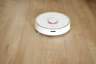 Kablosuz özerk akıllı robot elektrikli süpürge oturma odasındaki modern fayanslarla yerleri süpürüyor. Otomatik itişli temizlik robotu. Yer temizleme sistemi. Ev kumandası aygıtları