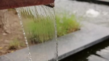 Düz paslı metal yapıyı kapatın ve aşağı güçlü temiz su aksın. Taze içme suyu çeşmesi açık havada. Su kaynağı. Endüstride doğal kaynakların aşırı tüketimi.