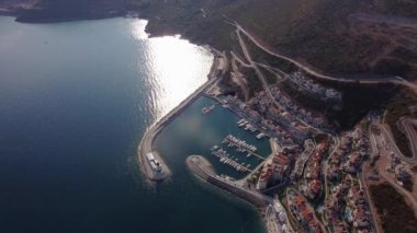 Lustica Körfezi, Adriyatik denizi, Karadağ 'ın havadan görünüşü. Binaların üst manzarası, liman limanı, demirli tekneler, yatlar ve deniz feneri, dağların arka planında. Yeni modern lüks tatil köyü.