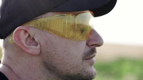 모자와 노란색 야외에서 베어드 남자를 닫습니다 플라스틱 안경으로 건축업자 노동자의 — 비디오