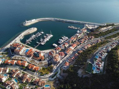 Lustica Körfezi, Adriyatik denizi, Karadağ 'ın havadan görünüşü. Binaların üst manzarası, liman limanı, demirli tekneler, yatlar ve deniz feneri, dağların arka planında. Yeni modern lüks tatil köyü.