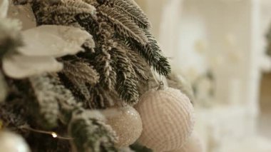 Parlak beyaz mücevherleri, topları, altın kostüm süsleri ve ışıkları olan köknar dallarının yakın görüntüsü. Tatil geçmişi. Noel ağacının süslemesi. Yeni bir 2024 yılı kutlaması. Boşluğu kopyala